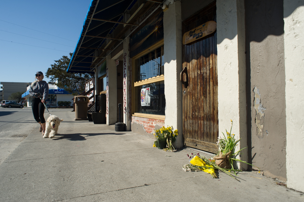 Flowers laid at the door of Red Dogs after the passing of former owner Charlie Maultsby, who started the bar in 1975. (Port City Daily photo/Mark Darrough)