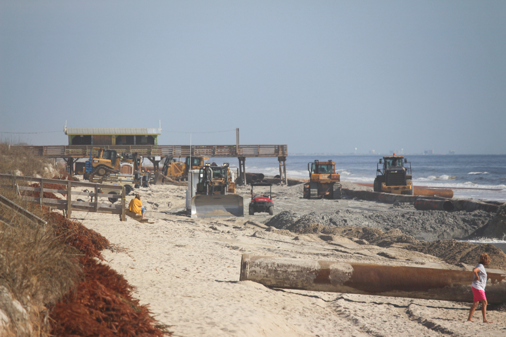 Despite being closed in portions, plenty of people can be seen out on the beach observing the beach nourishment process (Port City Daily/Michael Praats)