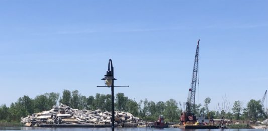 Situated just across the river from where the North Riverfront Park is planned sits a large pile of debris from an industrial company, but according to the county, there is no violation taking place (Port City Daily/Michael Praats)