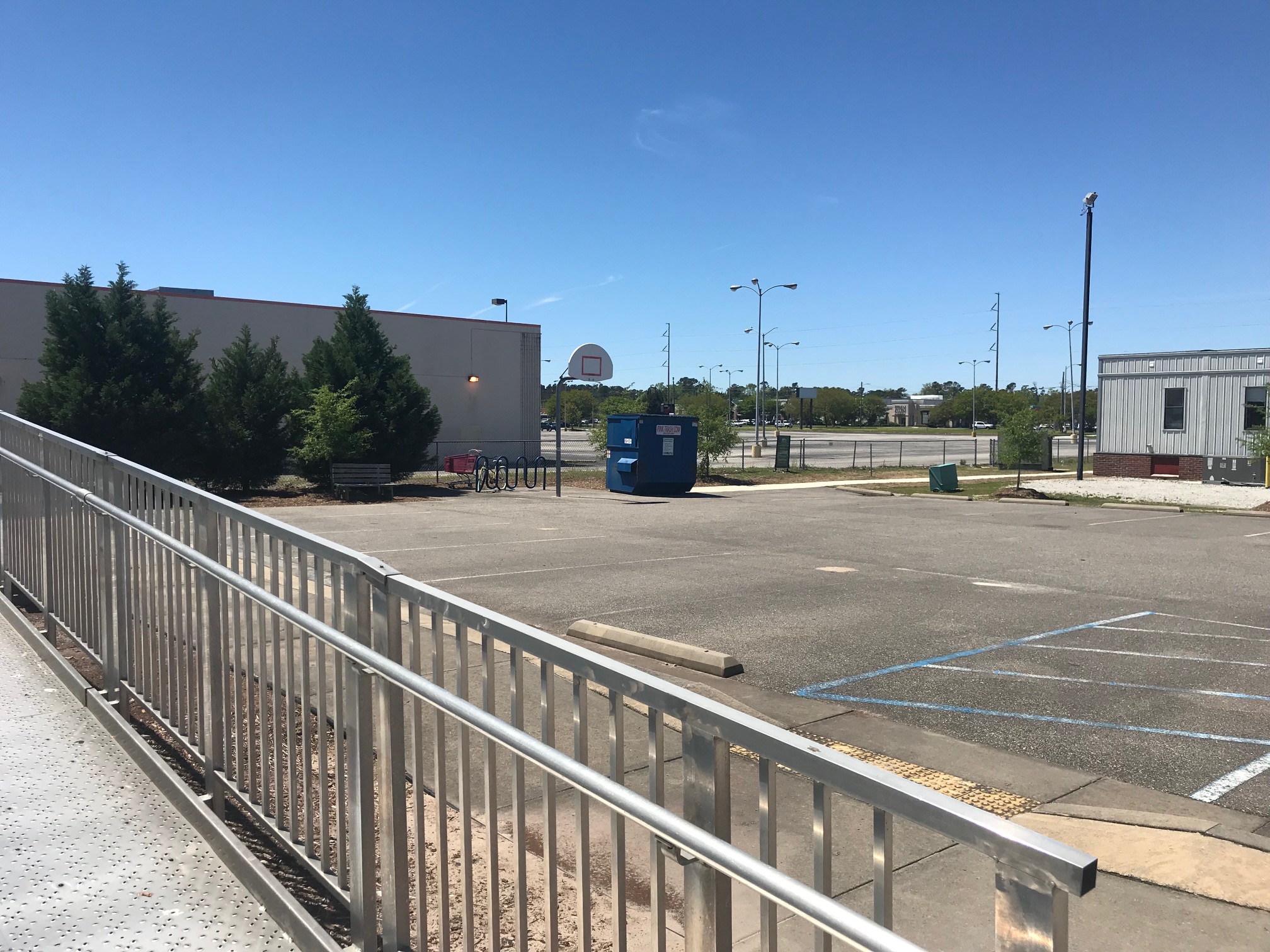 A parking lot with a dumpster and a basketball net is the open space for Isaac Bear Early College High School. (Port City Daily photo / Benjamin Schachtman)