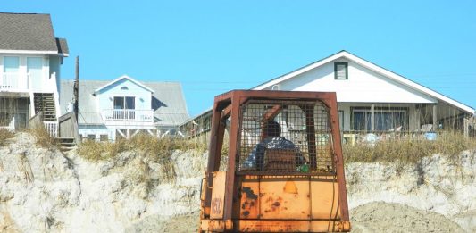 A bulldozer pushes sand up the beach near the 1200 block of South Shore Drive in early March. (Port City Daily photo/Courtesy Town of Surf City)