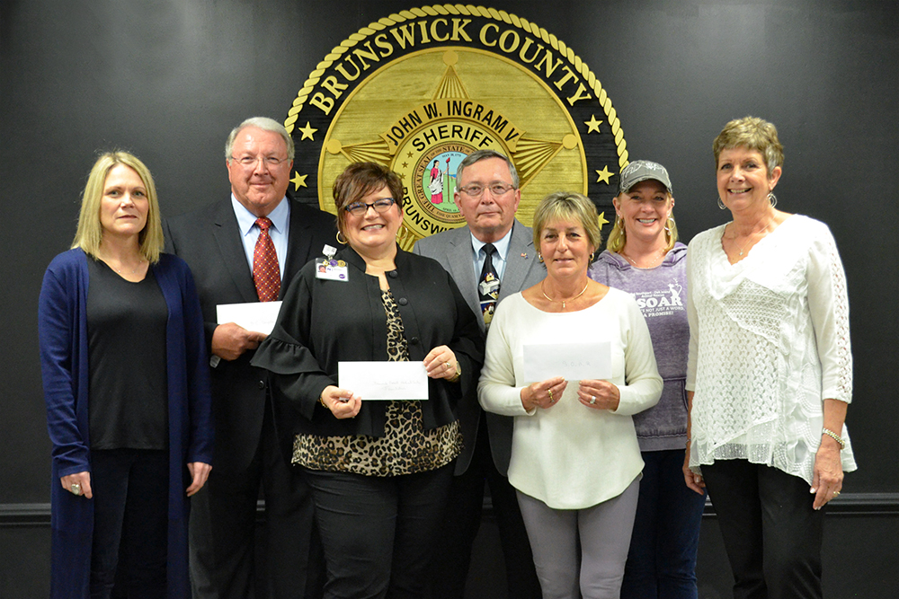 From left to right: Foundation Vice Chair Michelle Ingram, Doug Koontz, Cynthia Cheatham, Chris Breissinger, Cathy FitzGerald, Michelle Anthony, and Foundation Chair Monique Stenquist present the Brunswick Sherrif's Charitable Foundation's contribution as a result of the Diamonds and Denim Ball. (Port City Daily/Courtesy Brunswick County Sheriff's Office)