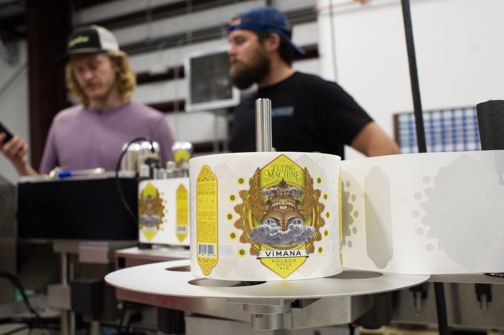 Head brewer Carl Cross, right, and quality assurance manager Dean Moore adjust settings on the new canning system. (Port City Daily photo?Mark Darrough)
