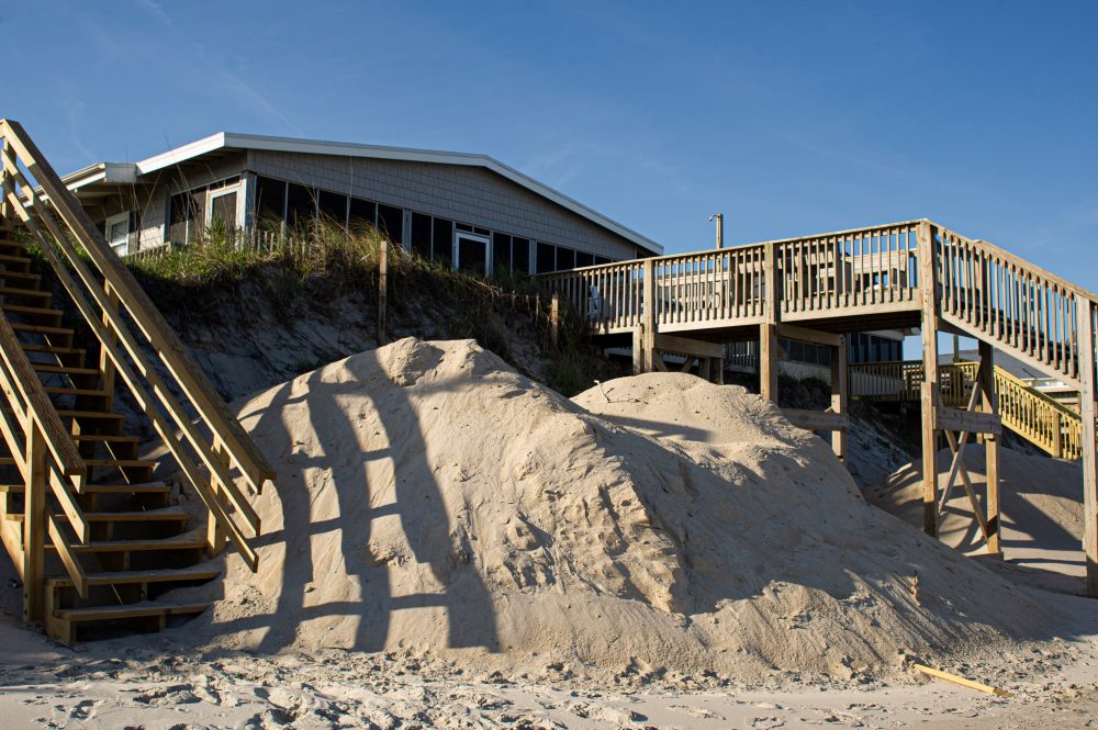 A pile of sand sits outside an oceanfront home in Surf City. In March, the NCDEQ shut down the town's sand-hauling dune rebuilding project after finding pebbles in the sand. (Port City Daily photo/Mark Darrough)