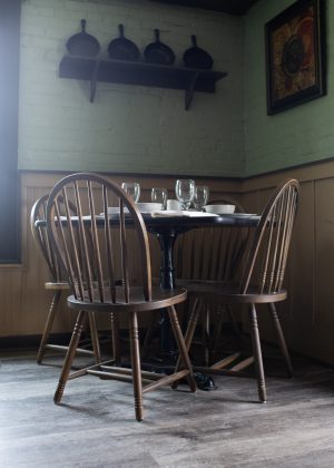 A table in the upstairs dining room is permanently set for a family of four who one local ghost tour guide died in a mid-19th century fire. (Port City Daily photo/Mark Darrough)