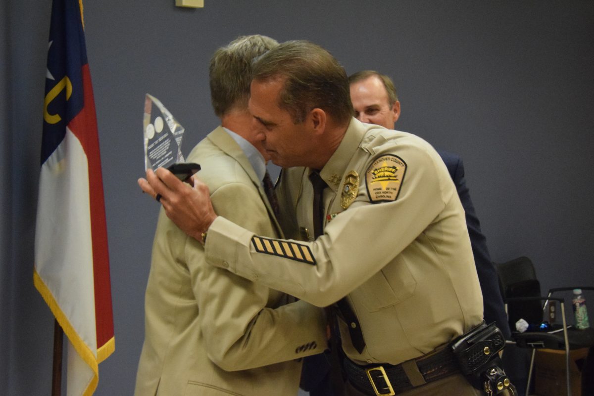 New Hanover County Sheriff Ed McMahon embraces former Deputy Superintendent Dr. Rick Holliday during an award ceremony on August 7. (Port City Daily photo / New Hanover County Sheriff's Office)