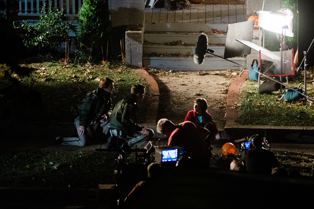 Two actors playing police officers talk to a young boy before he runs down Pender Avenue Friday night. (Port City Daily photo/Mark Darrough)