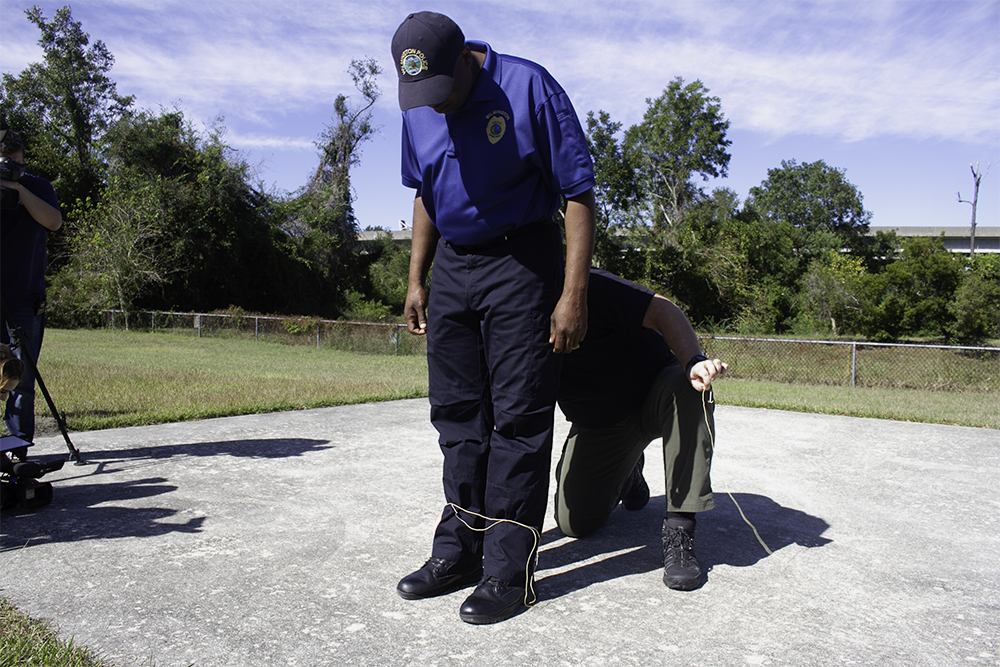 Assistant Chief acts as a detainee at a BolaWrap demonstration Wednesday. (Port City Daily photo/Johanna Ferebee)