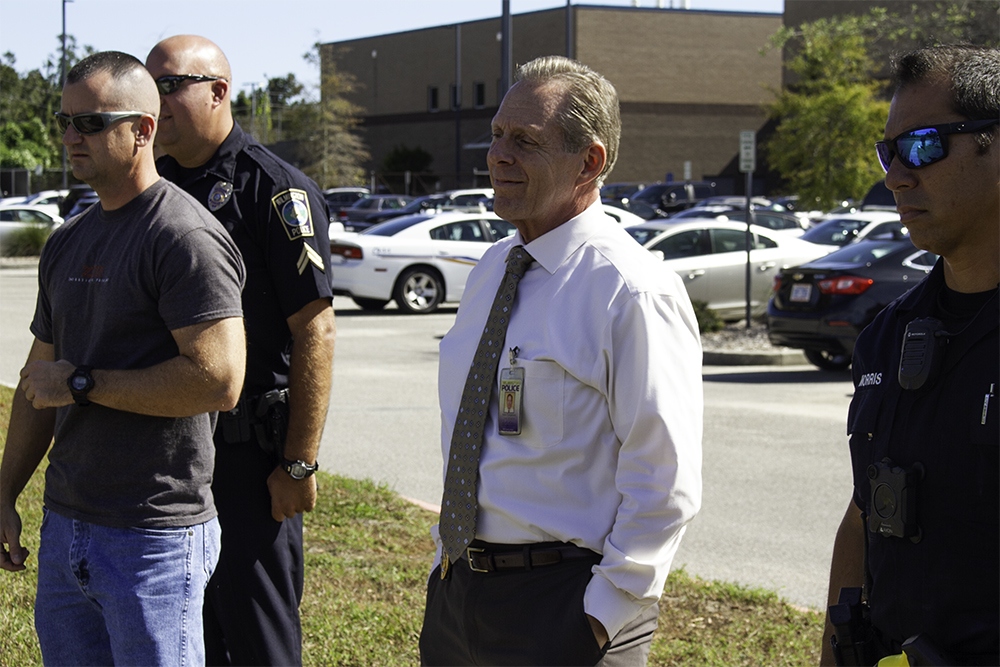 Chief of Police Ralph Evangeolous (center) observes the BolaWrap demonstration Wednesday. (Port City Daily photo/Johanna Ferebee)