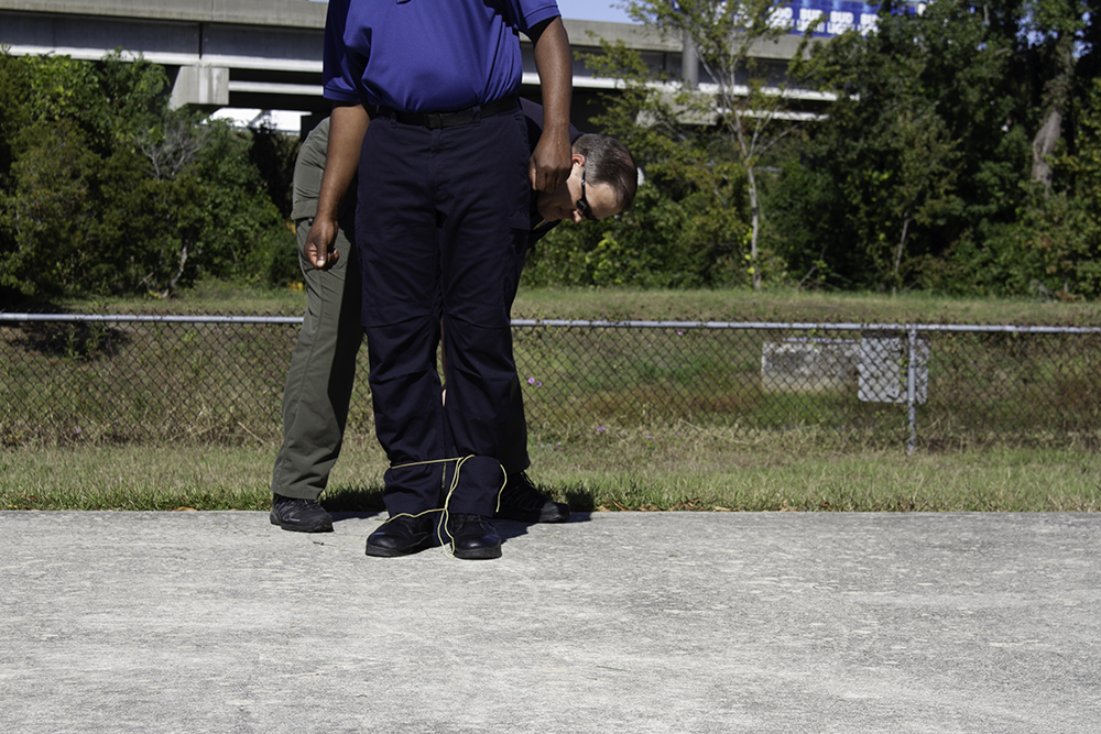 Assistant Chief acts as a detainee at a BolaWrap demonstration Wednesday. (Port City Daily photo/Johanna Ferebee)