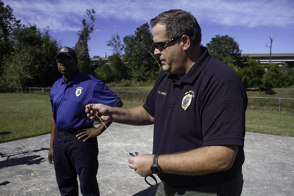 Assistant Police Cheif Donnie Wiliams (left) and Lt. Kevin Johnson demonstrate Wilmington Police Department's new non-lethal device, the BolaWrap. (Port City Daily photo/Johanna Ferebee)
