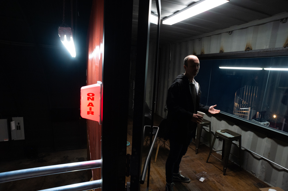 Bespoke Coffe owner Chris Batten shows a container installed above the bakery, which will eventually be outfitted as a 'podcast room' where local podcast hosts can broadcast live to customers downstairs. (Port City Daily photo/Mark Darrough)