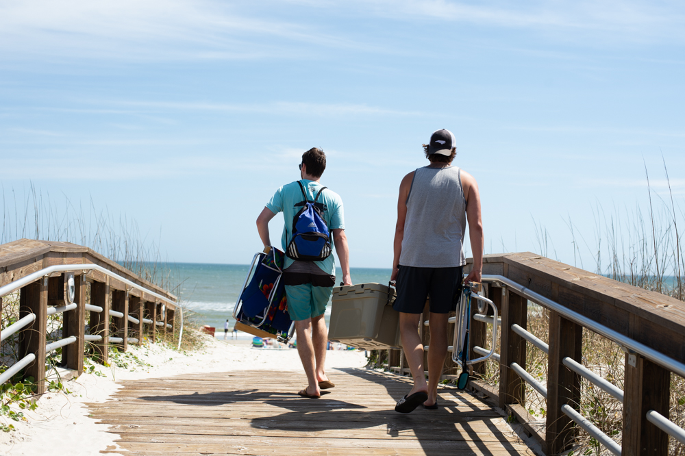 Two young men head to the beach through the Pelican Road access on Friday afternoon. (Port City Daily photo/Mark Darrough)