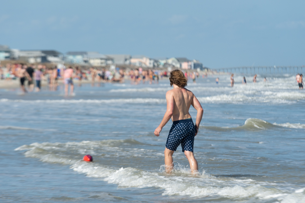 A young man plays catch with a friend at Carolina Beach late Friday afternoon. (Port City Daily photo/Mark Darrough) 