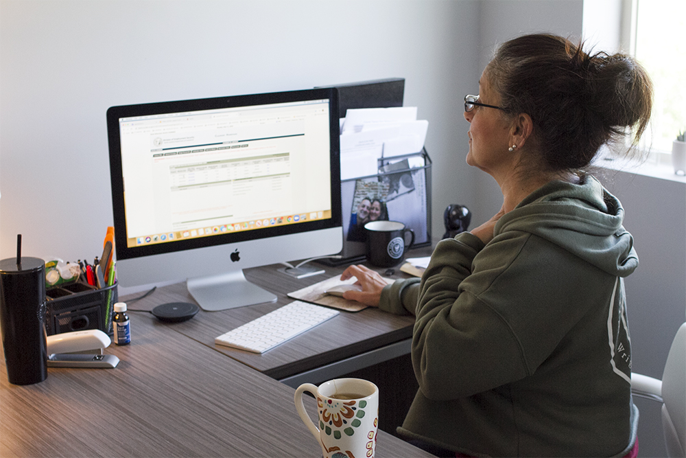 Julie Romero, owner of Hands in the Sands, looks at her N.C. Department of Employment Security portal Monday, hoping for an update that hasn't yet come. (Port City Daily photo/Johanna F. Still)