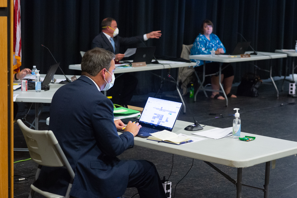 Pender County Schools Superintendent Steven Hill looks on as Chairman Don Hall speaks during a Board of Education meeting earlier this summer. (Port City Daily photo/Mark Darrough)