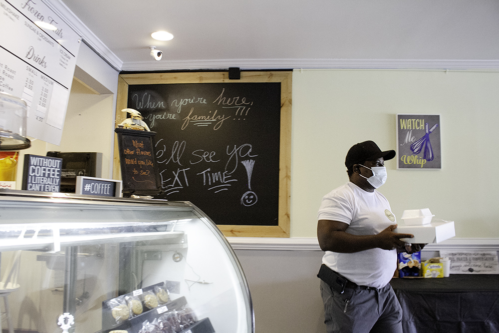 Brian Dickey carries a take-out order to a customer in Sweet D's Cuisine, a new bakery located near the hospital on 17th Street. (Port City Daily photo/Johanna F. Still)