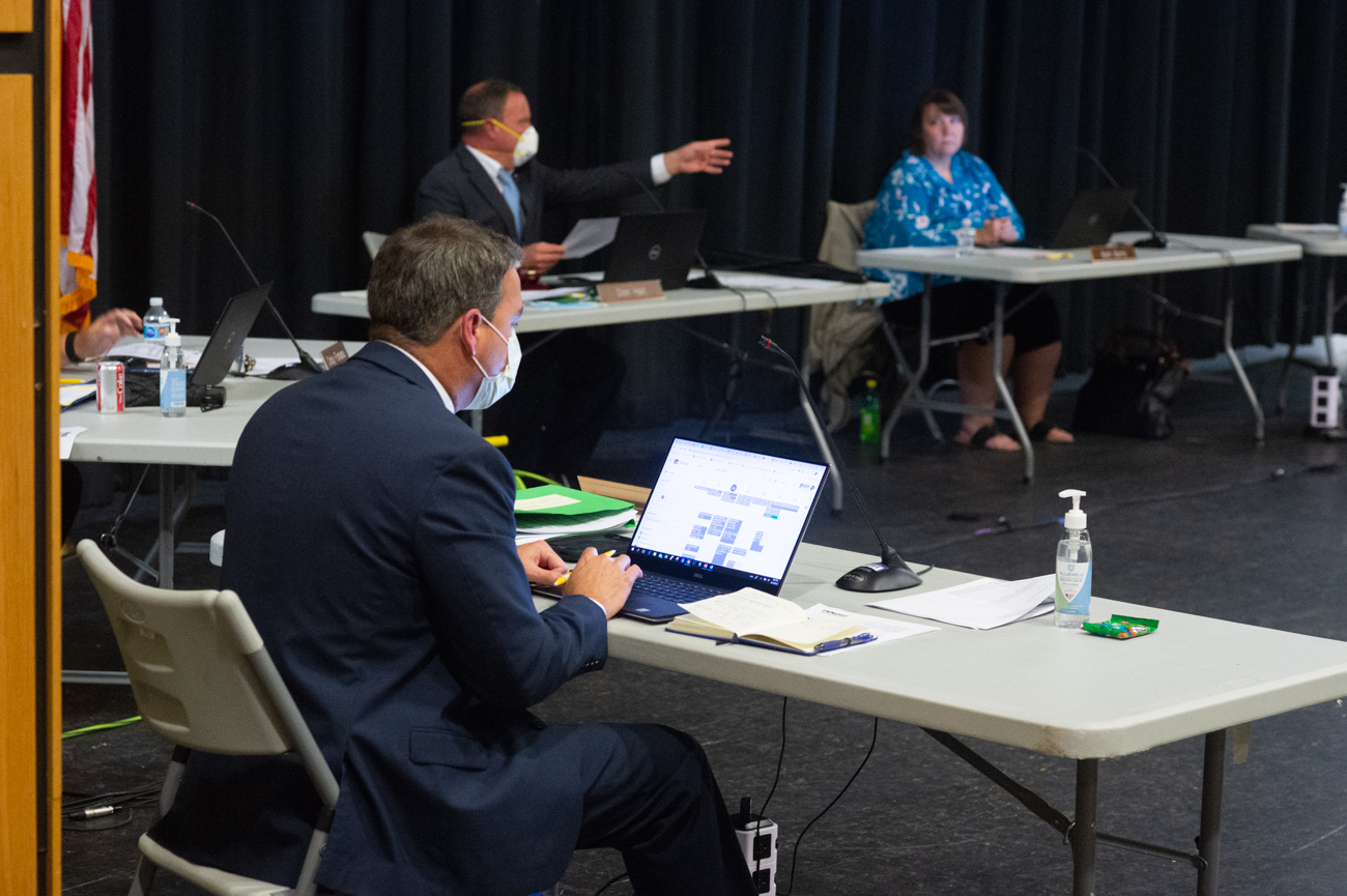 Pender County Schools Superintendent Steven Hill looks at his calendar as PCS Board of Education Chairman Don Hall speaks at a June board meeting. (Port City Daily photo/Mark Darrough)