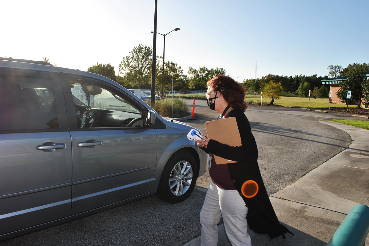 A Virginia Williamson Elementary School staffer prepares to conduct a temperature check before school begins. (Port City Daily photo/Courtesy BCS)
