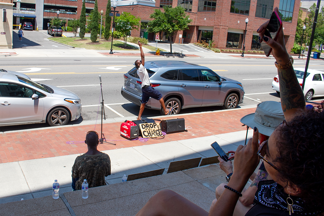 (Right) Nicole Nelson (known as Lily Nicole) sits on the steps of Wilmington City Hall Thursday morning ahead of her court appearance for charges related to an alleged October 2020 vandalization of a Trump billboard. (Port City Daily photo/Johanna F. Still)