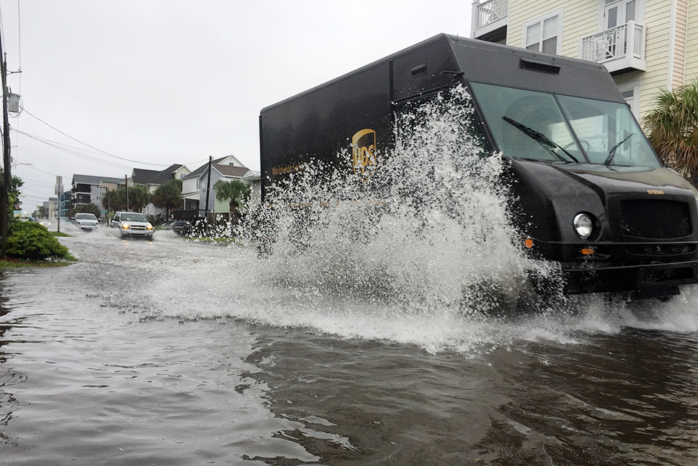 A UPS delivery truck drives through saltwater on Canal Drive in Carolina Beach. (Port City Daily photo/Johanna F. Still)