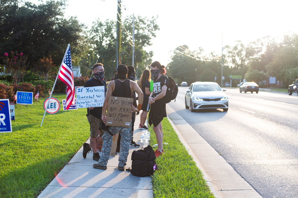 Black Lives Matter protestors hold up signs on Market Street outside the New Hanover County Republican Party office Wednesday evening. (Port City Daily photo/Mark Darrough)