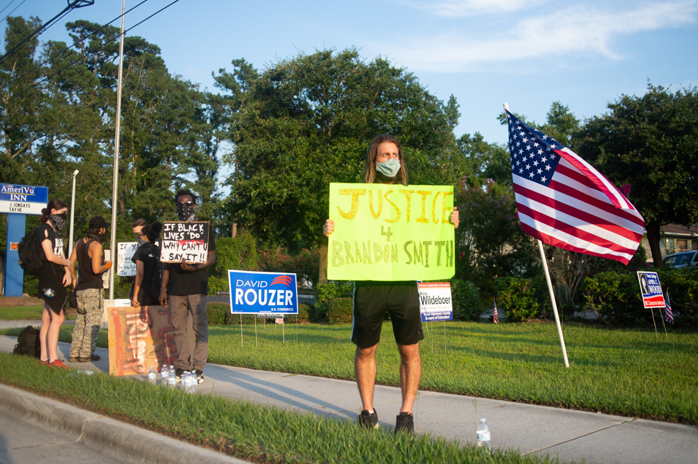 Black Lives Matter protestor Zach Ulrich hold up a sign on Market Street outside the New Hanover County Republican Party office Wednesday evening. (Port City Daily photo/Mark Darrough)