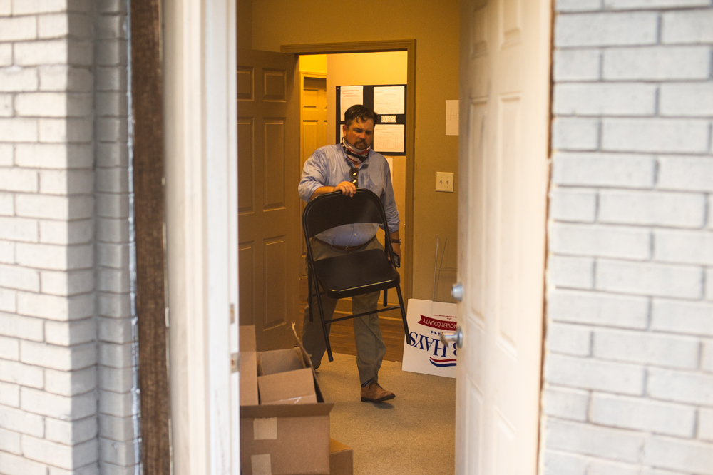 A campaign staffer for U.S. Congressman David Rouzer carries a chair through the New Hanover County Republican Party Wednesday office evening. (Port City Daily photo/Mark Darrough)