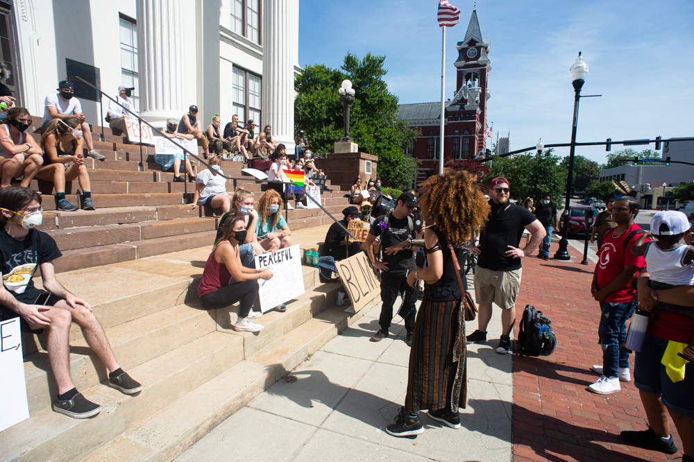 Lily Nicole, center, who has become one of the de facto leaders of the protest after reaching a compromise with Wilmington Police Interim Chief Donny Williams in the middle of Sunday night's protests, talks to protestors on the steps of City Hall after a peace march alongside the WPD and other city leaders Wednesday afternoon. (Port City Daily photo/Mark Darrough)