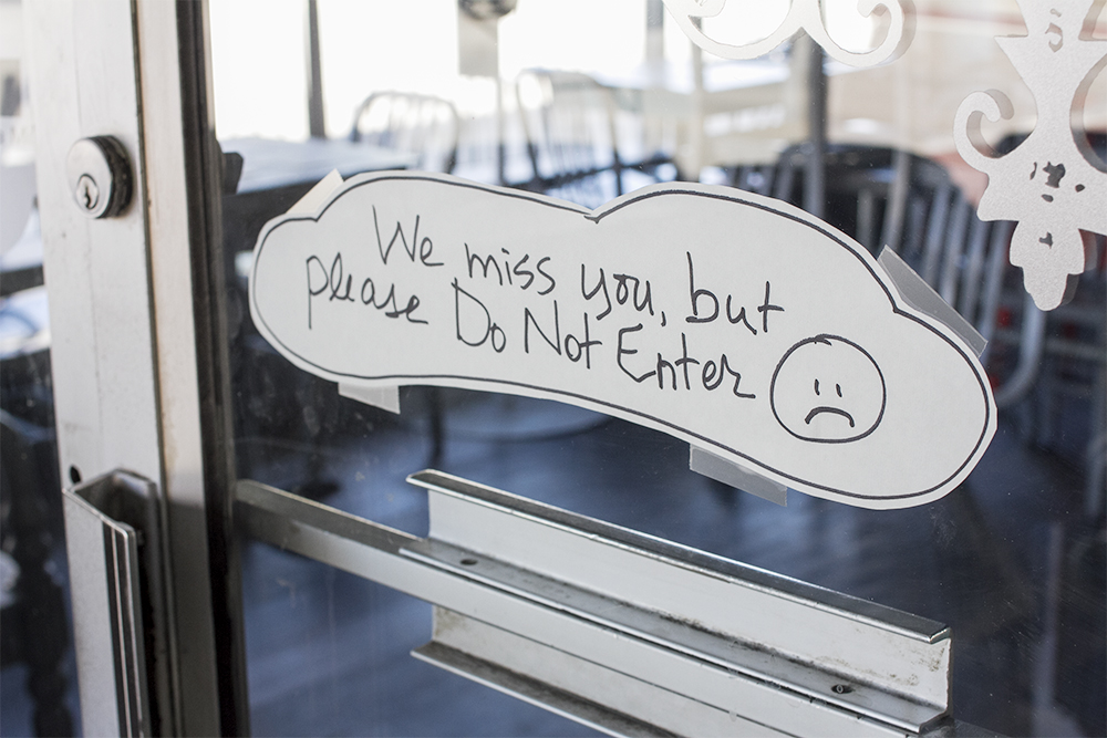 A handwritten sign taped outside Beer Barrio in downtown Wilmington. (Port City Daily photo/Johanna F. Still)