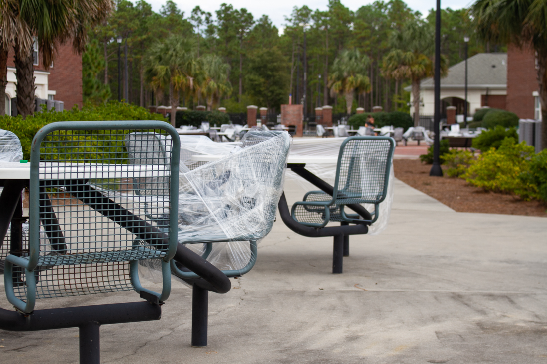Outdoor seating remains wrapped in plastic at the University of North Carolina at Wilmington amid continued Covid-19 protective measures on campus. (Port City Daily photo/Preston Lennon)