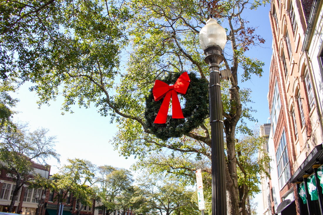 Wreaths with fat red bows have adorned city light fixtures downtown as early as Nov. 1 to prepare for Christmas. (Port City Daily photo/Johanna F. Still)